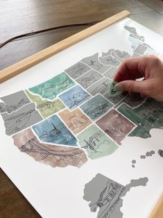 a person's hand is drawing on a map of the united states with colored pencils