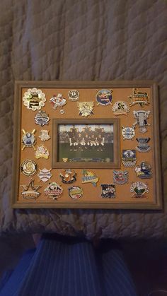 a wooden frame with many different badges on the front and back of it, along with an image of a football team