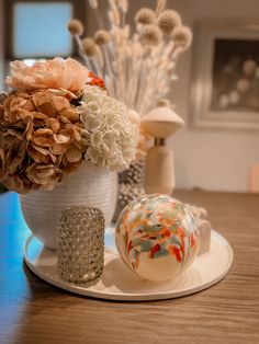 a vase filled with flowers sitting on top of a wooden table