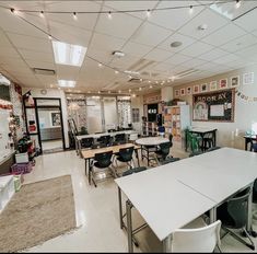 an empty classroom with desks, chairs and pictures on the wall above them is seen in this image