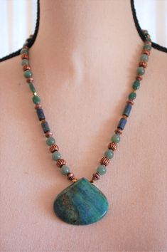 I designed and hand crafted this lovely hand beaded pendant necklace.  It has a beautiful natural stone chrysocolla teardrop shaped pendant, and natural stone, crystal, glass, and antiqued copper metallic beads.  The natural stone and glass bead colors are mostly green, with a touch of blue.  This necklace measures 21 inches in length, and the teardrop shaped pendant adds an additional 1.75 Inches.  It has a j-hook clasp, is one of a kind, and is comfortable to wear. Ours is a non-smoking home. Hand-strung Dangle Necklaces Perfect For Gifts, Handmade Earthy Turquoise Necklace For Gift, Hand-strung Dangle Necklaces For Gifts, Handmade Teardrop Beaded Necklace, Spiritual Teardrop Beaded Necklaces For Jewelry Making, Bohemian Beaded Drop Necklace As Gift, Bohemian Beaded Drop Necklace For Gift, Beaded Teardrop Pendant Drop Necklace For Gift, Handmade Jade Beaded Necklaces