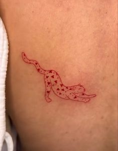 a cat tattoo on the back of a woman's stomach, with red ink