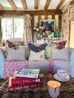 a living room filled with lots of furniture and pillows on top of a coffee table