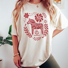 Get ready to be OBSESSED with your new Scandinavian Christmas Crewneck shirt. It's the cutest and most trendy way to combine all those important trendy Hygee vibes! This is the perfect Swedish holiday shirt!  * Q U I C K * F A C T S * ✺  All shirts are UNISEX ✺  100%  ringspun cotton (fiber content may vary for different colors) ✺  Soft-washed, garment-dyed fabric brings extra coziness ✺  Wash and dry normally (on cool for best results) ✺  Sewn-in twill label * S I Z I N G * ✺ For an oversized fit, select two or three sizes up from your normal size ✺ Model is wearing size L  ✺ Sizing runs true to size ✺ Relaxed fit ✺ Most women find their typical size works best, since they are meant to fit a touch loose ✺ See Size guide and fit in images          * S H I P P I N G * T I M E S * ✺ Our item Holiday Cotton Graphic Tee Shirt, Cotton Graphic Tee Shirt For Holidays, Cute Cotton Holiday Tops, Festive Cotton Graphic Print T-shirt, Festive Cotton T-shirt With Graphic Print, Holiday Cotton Tops With Relaxed Fit, Christmas Cotton Tops With Screen Print, Christmas Cotton Top With Screen Print, Festive Short Sleeve Cotton Tops