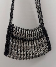 a black and silver purse hanging on a wall