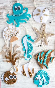 some decorated cookies are on a table with string and beads in the shape of sea animals