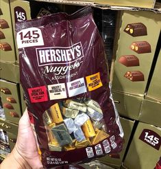 someone holding up a bag of hershey's fudges at a store