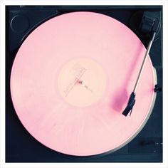 a pink record player with a black handle