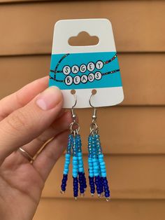 a pair of earrings with beads hanging from them