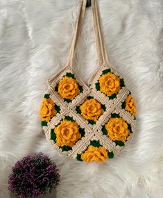 a crocheted bag with yellow flowers on it