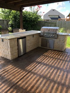 an outdoor kitchen with stainless steel appliances and grill