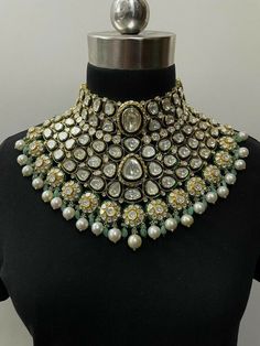 an elaborate necklace is displayed on a mannequin's neckline with pearls and stones