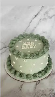 a green and white cake sitting on top of a marble counter