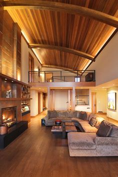 a living room filled with furniture and a fire place in the middle of an open floor plan