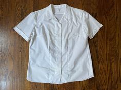 Stellar 1960s crisp white uniform blouse in nice vintage condition! This was found folded and pinned in its original plastic wrapping, but there was some major yellowing of some of the areas of the blouse that were on the outside of the folds. It's been soaked and most of the yellowing has lifted out. There's a very faint bit of yellowing in back, as pictured, but could lift out with another soak or bleach. Otherwise no major flaws to note!   Tag in the collar reads: RN 41337, Made in U.S.A., Cu Ladies Uniform, 1960s Blouse, White Uniform, Boat Neck Blouse, Uniform Shirt, Uniform Shirts, Cuffed Shorts, Dream Clothes, Vintage 1960s