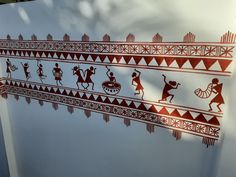 some red and white designs on the side of a wall in front of a building