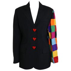 - This one of a kind avant grade vintage 90s Moschino Couture black jacket is beautifully done. Featuring one shoulder of multicolour patchwork with three black/white swirled buttons at the cuff. Three wooden red heart buttons in front fastening and also at the other sleeve cuff. Two front pockets at each side of the waist and also an interior pocket. - Made in Italy. - Size IT42, FR38, US8. - 55% Acetate, 45% Rayon. Double Lining 60% Acetate, 40% Rayon. - Height: 28in, Sleeve, 15in, Bust: 32in, Waist: 30in. (measurements are approximate. It is a straight line jacket. Cheap Black Tops With Three Stripes, Moschino 90s, Tv Static, Fashion Museum, Vintage Moschino, Adopt Idea, Patchwork Sleeve, Jackets Black, Moschino Couture