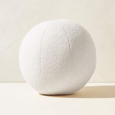 a white ball sitting on top of a wooden table