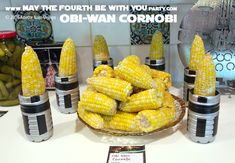 corn on the cob is sitting in front of several other containers with jars around them