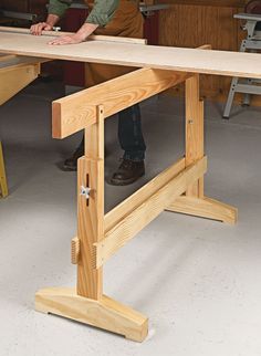 a man working on a wooden table in a workshop