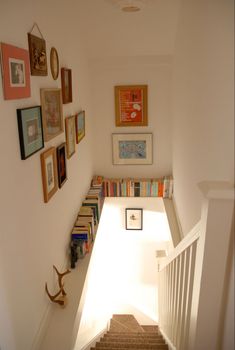 the stairs are lined with books and pictures