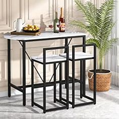 a table with three stools next to a potted plant