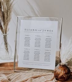 a table plan is displayed in front of a vase with pamodia and dried grass