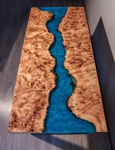 a wooden table with blue water flowing down the center and on it's sides