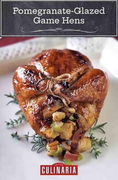 a white plate topped with a turkey covered in sauce and garnished with herbs