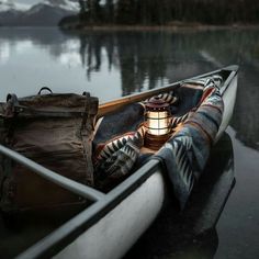 a boat with a light on it is sitting in the water next to a lake