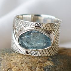 Natural Raw Gemstone Sterling Silver 925 Ring. Aquamarine is in Raw form and it has a beautiful intense vivid color. DETAILS: - Gemstone: Aquamarine - Nature: Natural - Shape: Uncut Raw Rough - Size: 8-12mm (approx) - Quality: AAA - Base Metal: Pure Sterling Silver 925 - Ring Style: Bezel - Band Color: Sterling Silver, Rhodium Over Silver, Rose Gold Overlay, Gold Overlay (Choose Band Color in option) PLEASE NOTE: - THIS IS A MODEL RING, THE ACTUAL RING WILL LOOK SIMILAR - The Ring shown in the p Silver Rings With Blue Topaz Stone Setting, Silver Ring With Large Stone Fine Jewelry, Unique Silver Topaz Ring With Stone Setting, Silver Wide Band Jewelry With Gemstone, Silver Wide-band Jewelry With Gemstones, Silver Open Ring With Gemstone Accents, Silver Rings With Blue Topaz Accent Stones, Silver Topaz Ring For Jewelry Making, Silver Gemstone Rings For Jewelry Making