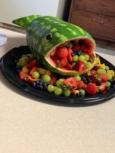 a watermelon shaped like a shark with fruit in it's mouth on a plate