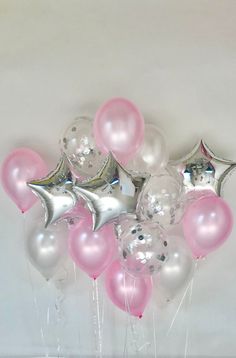 a bunch of balloons that are in the shape of stars on a white background with pink and silver foil