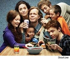 a group of people sitting around a table with food and drinks on the table in front of them