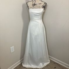 a white wedding dress hanging on a hanger