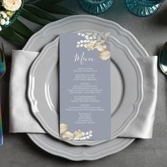 a place setting with silverware and flowers on the plate, along with menu cards