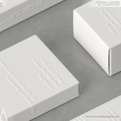 two white boxes sitting next to each other on top of a gray surface with the words,