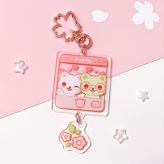 a pink cell phone keychain with two cats on it