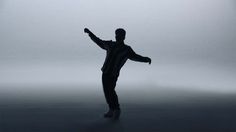 a man standing in the fog with his arms outstretched