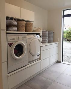 a washer and dryer sitting in a room next to a window with open doors