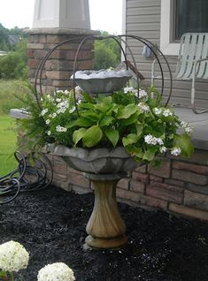 a planter filled with flowers sitting on the side of a house