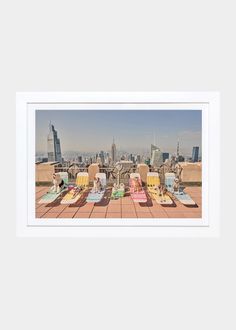 three lawn chairs sitting on top of a wooden floor next to each other in front of a city skyline