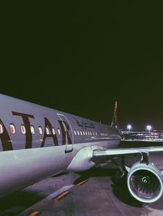 an airplane is parked on the tarmac at night