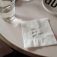 a napkin with the words call for a good time written on it next to a glass of water