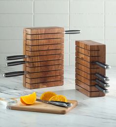 a cutting board with knives and orange slices on it