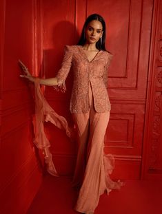 Dusty peach power shoulder crop jacket with cropped sleeves heavily hand embellished with our self geometric leaf design. The jacket features glass beaded tassels at the sleeve hems. Paired with a flowy georgette pant featuring hand embellished scatters & a ruffle dupatta.From Shloka Khialani's Afterglow CollectionDELIVERY TIMEPlease allow 8-12 weeks for your outfit to arrive.FABRIC DETAILSGeorgette, Net, OrganzaSpot Dry Clean Only. Spring Evening Hand Embellished Sets, Spring Evening Hand-embellished Sets, Pink Party Sets With Tassels, Pink Tassel Party Set, Spring Party Sets With Tassels, Elegant Peach Sets For Reception, Elegant Peach Reception Set, Elegant Peach Sets For Festive Season, Elegant Peach Festive Sets