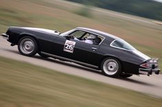 a black sports car driving on a track