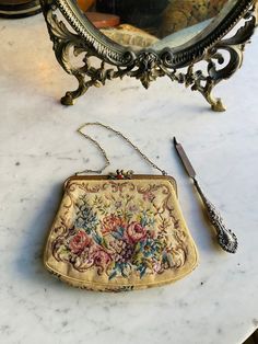 "Beautiful petit point (micro embroidery) purse with gold frame and fantastic jewels enhancing the closure.  The twisted wire chain is solid and the peice is in excellent unaltered condition with a . The gorgeous silk grosgrain lining lining is in excellent condition The purse measures 7 by 5 inches and is study enough for light use at a wedding or day or evening function, or as a gift.    Since Victorian times through the 1930s, petit point handbags were the gold standard for a lady of fashion. Micro Embroidery, Ladies Pouch, Victorian Purses, Embroidery Purse, 1890s Fashion, Victorian Times, Frame Purse, Framed Embroidery, Vintage Wardrobe