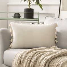 a living room with a couch, chair and potted plant on the side table