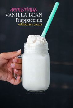 a hand holding a glass with whipped cream in it